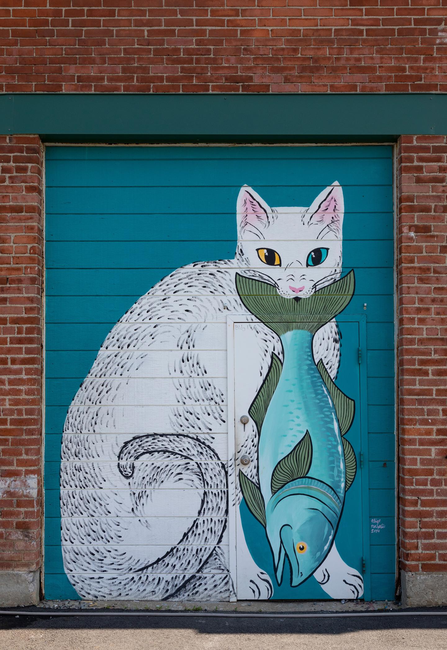 Mural painting of a cat holding a fish in its mouth